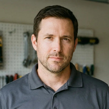 Man wearing a gray polo shirt in a workshop setting